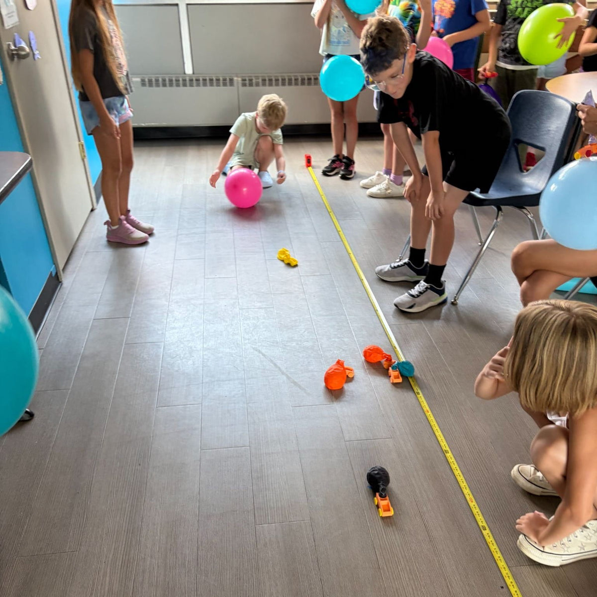 Students preparing and racing balloon-powered 3D-printed cars during the Summer STEM Series
